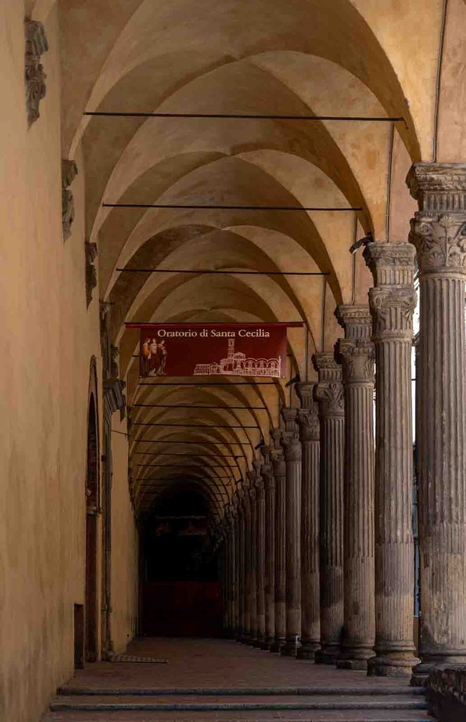 Long arcaded portico leading toward the Oratory of Saint Cecilia in Bologna.